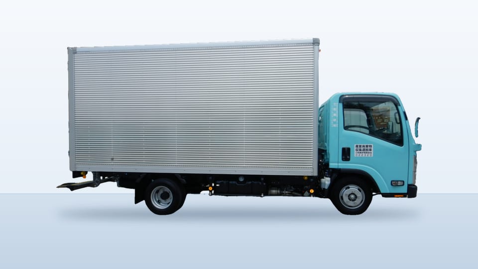 銀色の箱型の荷台を載せた、水色のボックス車の側面。