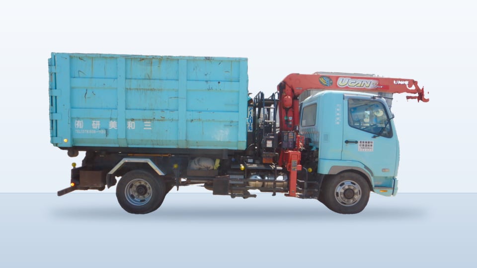 水色のユニック車。脱着式のコンテナを載せている。